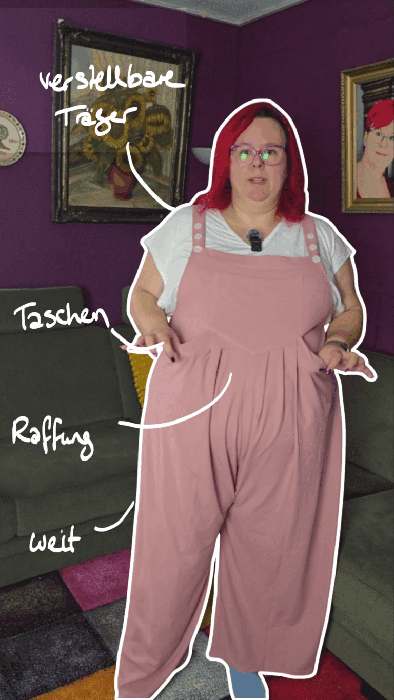 Dicke Frau mit roten Haaren trägt einen rosafarbenen weiten Jumpsuit, darunter ein weißes T-Shirt