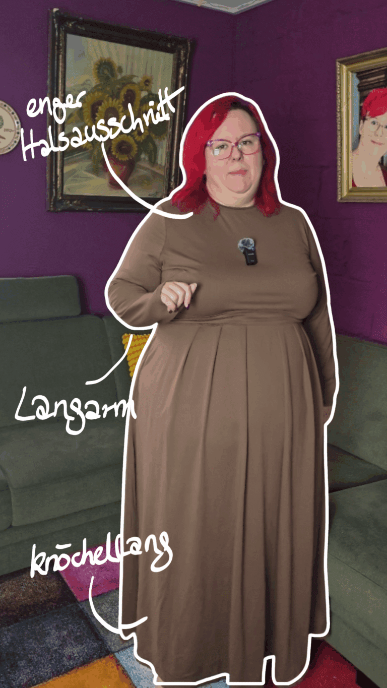 Dicke Frau mit roten Haaren trägt ein braunes Knöchellanges Kleid mit hohem Halsausschnitt und langen Ärmeln.