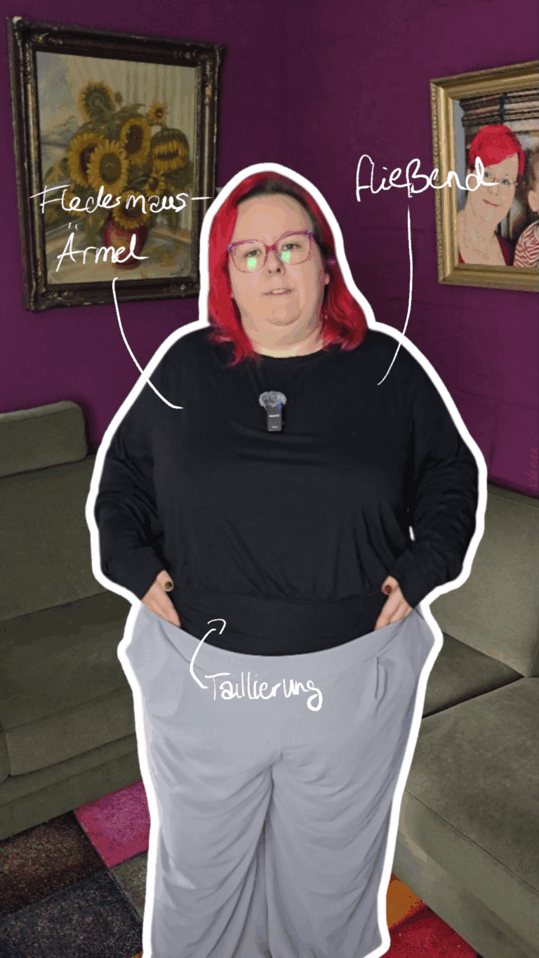 Dicke rothaarige Frau trägt ein schwarzes langärmliges lässiges Shirt mit Fledermausärmeln.