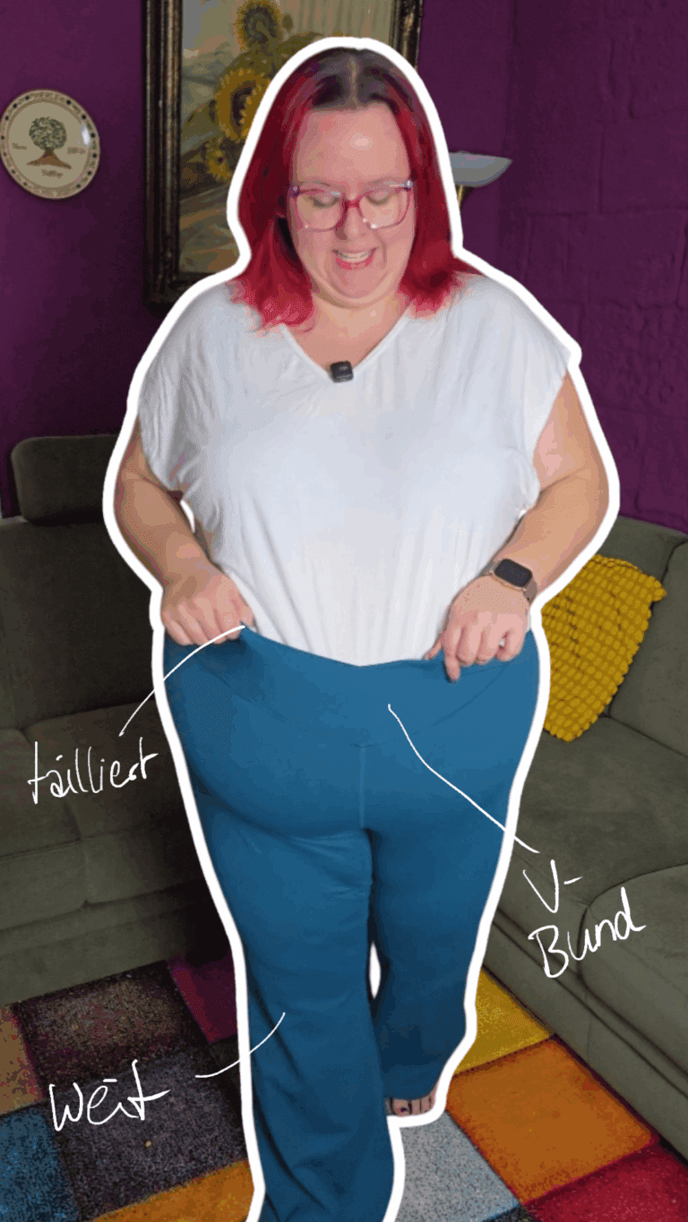 Dicke rothaarige Frau präsentiert eine petrolfarbene Sportleggings mit ausgestellten Beinen.