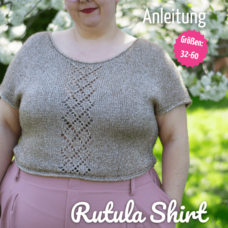 Dicke Frau trägt ein Beiges Strickshirt und eine Rosa Hose, im Hintergrund ist Garten und ein Kirschbsaum in Blüte zu sehen.